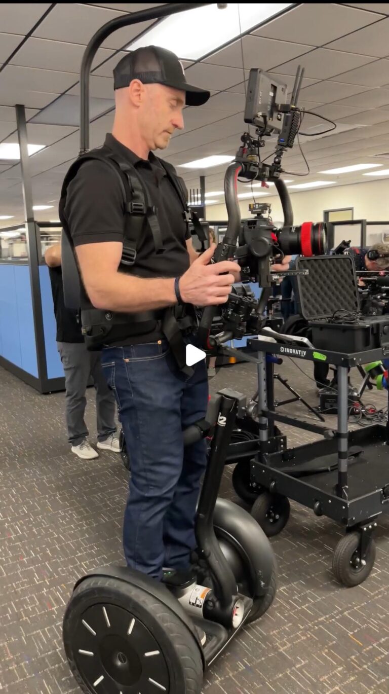 Charlotte gimbal operator Diego Torroija rigging a Canon cinema camera on a stabilized gimbal with a support vest
