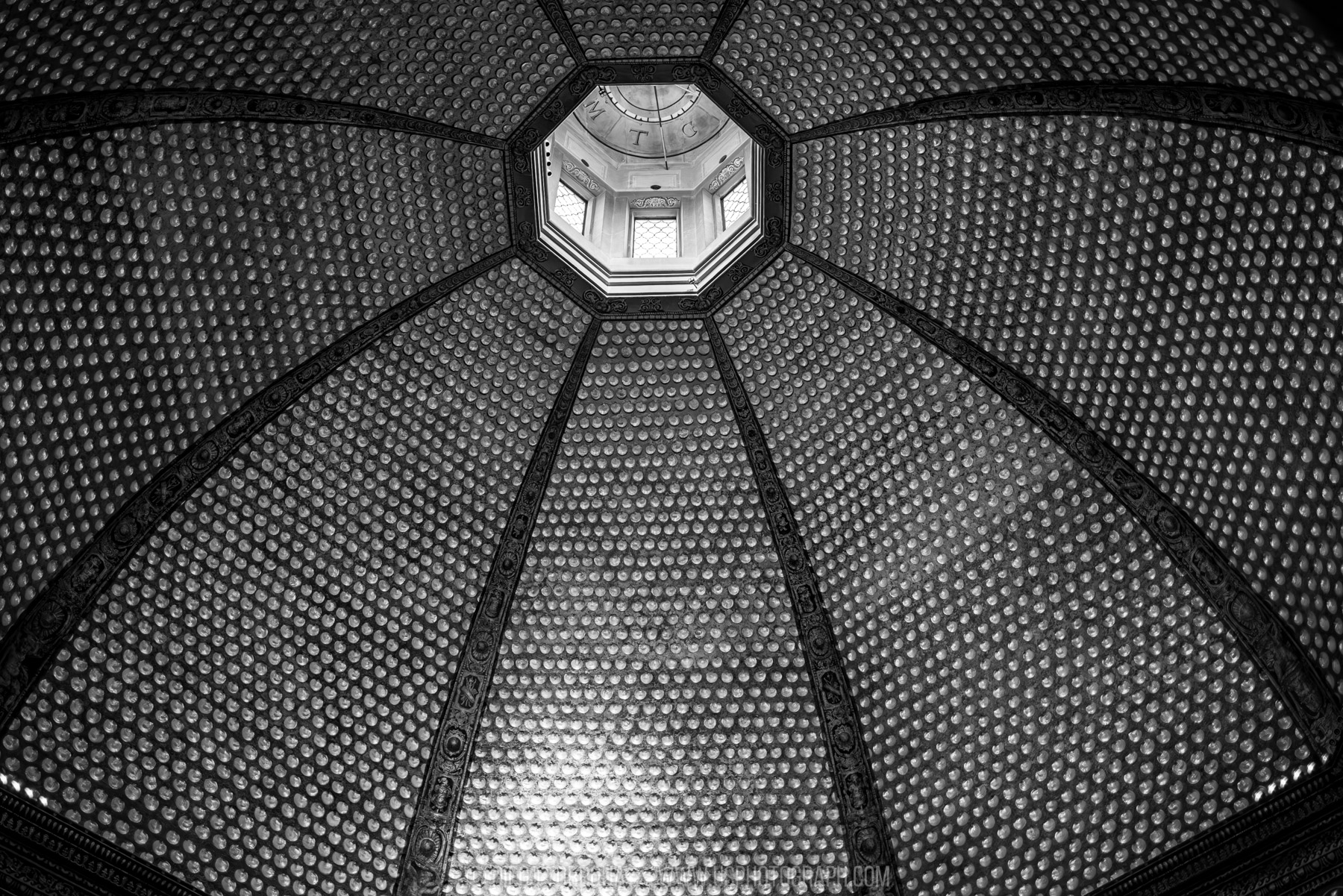 Looking up into an ornate octagonal dome and lantern in Florence, black and white architectural photography
