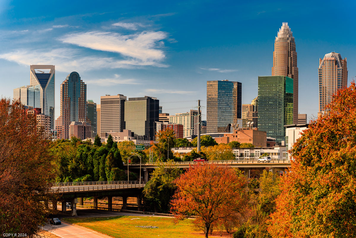 Charlotte city skyline over highway overpasses and fall foliage