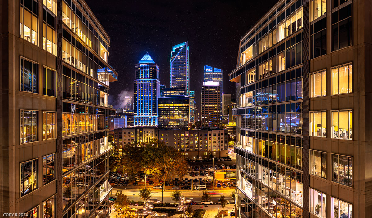 Uptown Charlotte skyline at night framed between glass towers
