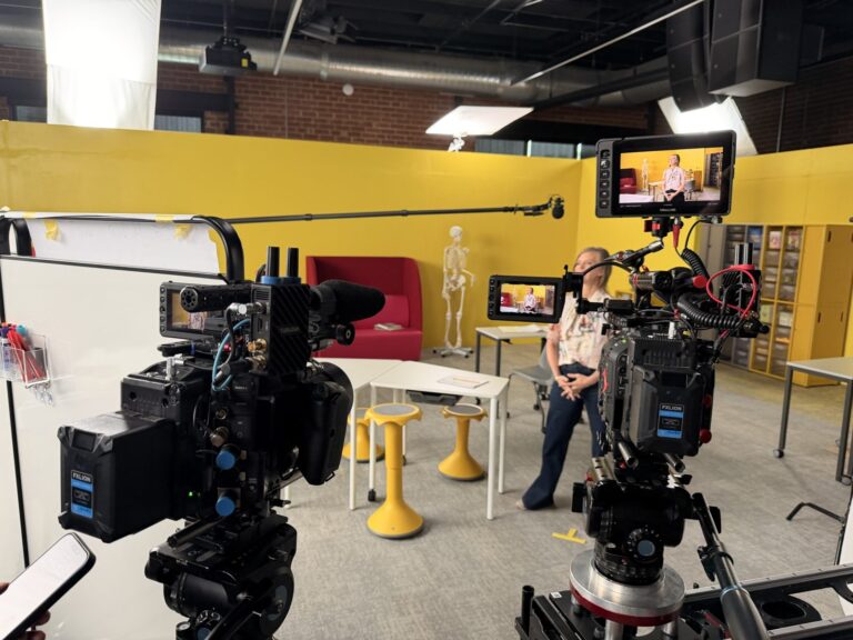 Two cinema cameras set up for an interview on a yellow classroom set in Charlotte